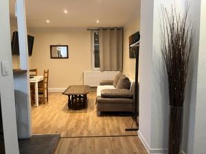 a living room with a couch and a table at Le Cosy Strasbourg calme et confortable avec parking gratuit, 10 mn du Parlement Européen et du Wacken de 1 à 24 voyageurs in Schiltigheim