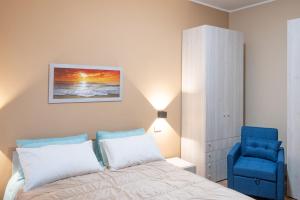 a bedroom with a bed and a blue chair at B&B Civico 15 in Nettuno