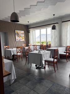 a dining room with tables and chairs and windows at Hotel Stadarborg in Breiðdalsvík +58 photos