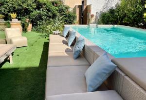 a swimming pool with pillows next to a patio with a swimming pool at Ricordi Siciliani - Charme Rooms in San Vito lo Capo