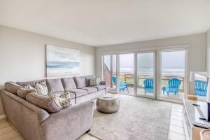 a living room with a couch and views of the ocean at Pacific Sands Unit #10 in Neskowin