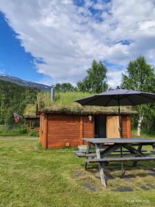 a picnic table with an umbrella next to a cabin at Reisa River Lodge in Potka +28 photos