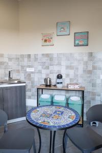 a kitchen with a table with two chairs and a sink at B&B Civico 15 in Nettuno