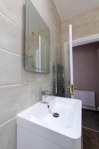 a bathroom with a white sink and a mirror at 18 Garden Mews in Cookstown +23 photos