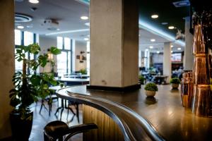 a bar in a restaurant with chairs and plants at Hotel Kiel-Schwedenkai in Kiel +93 photos
