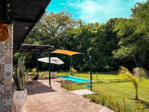 a swimming pool with an umbrella and a patio at Suite Quelepa San Miguel in Quelepa