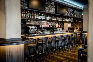 a bar with stools in a room with alcohol at Hotel Kiel-Schwedenkai in Kiel