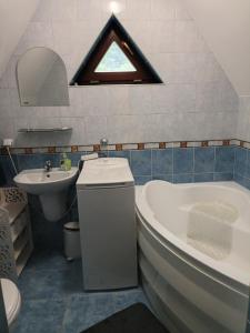 a bathroom with a sink and a tub and a toilet at Mazury, Domek pod Lasem in Koczek +17 photos