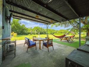 a patio with a table and chairs and a hammock at Suite Quelepa San Miguel in Quelepa