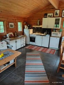 a kitchen with white appliances in a wooden cabin at Reisa River Lodge in Potka