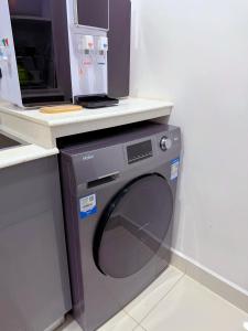 a washing machine with a microwave on top of it at Minique stay - spacious 3BR in Furena