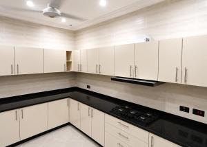 a kitchen with white cabinets and black counter tops at CB Apartment in Santeo