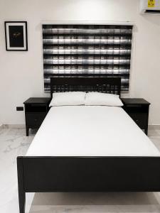a bedroom with a large bed and a window at CB Apartment in Santeo