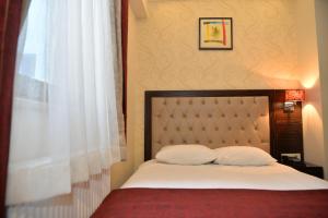 a bedroom with a bed with two pillows and a window at Golden Siyav Hotel in Istanbul