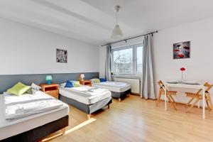 グダニスクにあるNice Rooms - Pokoje Gościnneのベッド2台とデスクが備わる客室です。