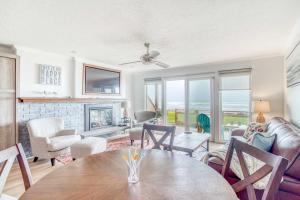 a living room with a table and chairs and a fireplace at Waveside Hideaway, Unit 11 in Neskowin +23 photos