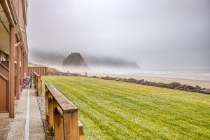 a view of a grassy field next to a building at Waveside Hideaway, Unit 11 in Neskowin