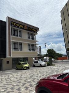 two cars parked in a parking lot in front of a hotel at Tdoze Hotel At Piccadilly Ipoh in Ipoh