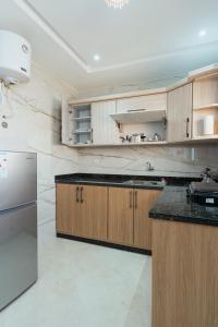 a kitchen with wooden cabinets and a stainless steel refrigerator at Sahoria Stay in Dakhla