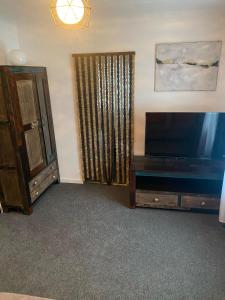 a living room with a flat screen tv and a cabinet at Alpenresidenz Viktoria in Türnitz +30 photos