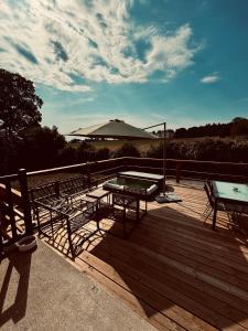 a deck with a table and two benches on it at Moulin de Micheline - Jacuzzi - Vue Exceptionnelle in Bourg-dʼIré