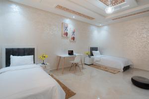 a bedroom with two beds and a desk in it at Sahoria Stay in Dakhla