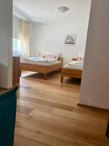 two beds in a room with wooden floors at Franz - Josef in Emmingen-Liptingen