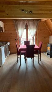 a dining room with a pink table and chairs at Vila Paradiso in Slatina Varoš