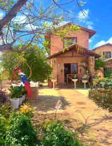 a brick house with a bird hanging from a tree at Estação Serrana in Pedro II