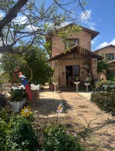 a brick house with a yard with flowers at Estação Serrana in Pedro II +4 photos