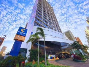 a tall building with a palm tree in front of it at Comfort Hotel Fortaleza in Fortaleza +45 photos