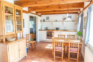 a kitchen with a wooden table and chairs at Ferienwohnung Schulkate I - Boldevitzer Rügenkaten in Parchtitz