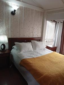 a bedroom with a bed and a lamp and a window at Casa 3 dormitorios estacionamiento Heriberto Ortiz in Santiago