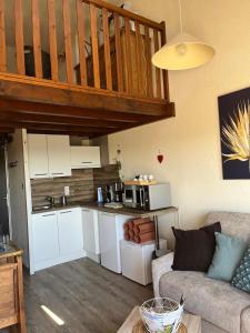 a living room with a couch and a kitchen at Duplex - Proche de Gérardmer in Le Tholy