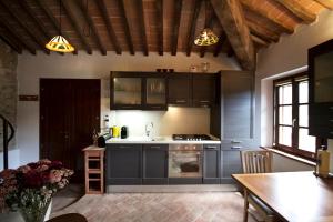 una cocina con armarios negros, fregadero y mesa en Giuliana en Camaiore
