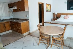 a kitchen with a table and chairs and a bed at Hotel La Joya Del Lago in Ajijic