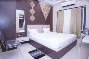 a bedroom with a bed and a chair in it at Hotel ganga sarovar Inn in Deoghar