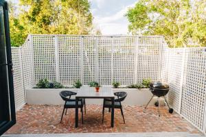 a patio with a table and chairs and a grill at Suite 273 - Luxe Solar Suite - Heated Pool in Cape Town