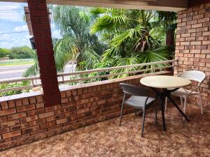 a patio with a table and chairs and a brick wall at 4bnb in Gaborone
