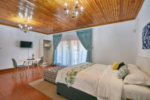 a bedroom with a bed with a wooden ceiling at 4bnb in Gaborone +1 photo