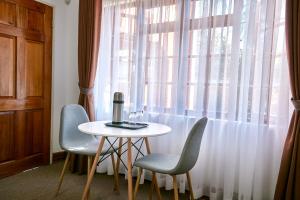 a table and two chairs in front of a window at 4bnb in Gaborone
