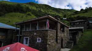 a stone building with a flag on top of it at Gudani Temi in Gudani +7 photos