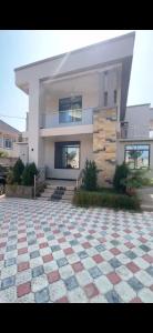 a house with a checkered floor in front of it at Rj Executive Apartments in Dodoma
