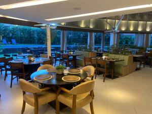 a restaurant with tables and chairs and windows at Comfort Hotel Fortaleza in Fortaleza