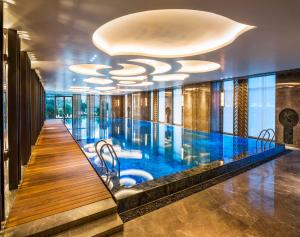 a swimming pool in a hotel lobby with a ceiling at Wanda Reign Chengdu in Chengdu