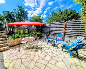 a patio with chairs and a table with an umbrella at LA Grâce d'Amboise in Amboise