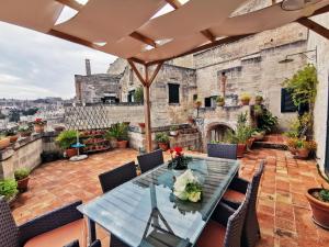 an outdoor patio with a table and chairs and a fireplace at Corte dei Venti in Matera