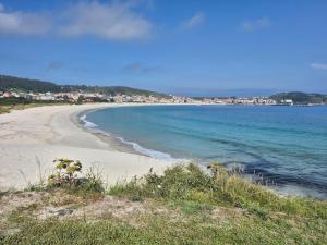 a view of a beach with buildings in the distance at Casa Beleví - Laxe, sea and rest in Laxe