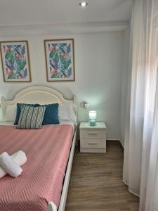 a bedroom with a bed with a pink blanket and a table at Casa Beleví - Laxe, sea and rest in Laxe