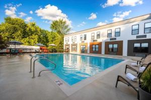 a swimming pool in front of a building at Red Roof Inn & Suites Middleborough in Middleboro